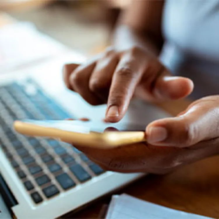 man using calculator while checking investments on laptop
