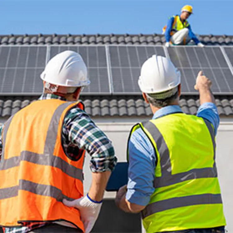 men standing in front of a house in renovation for solar panels