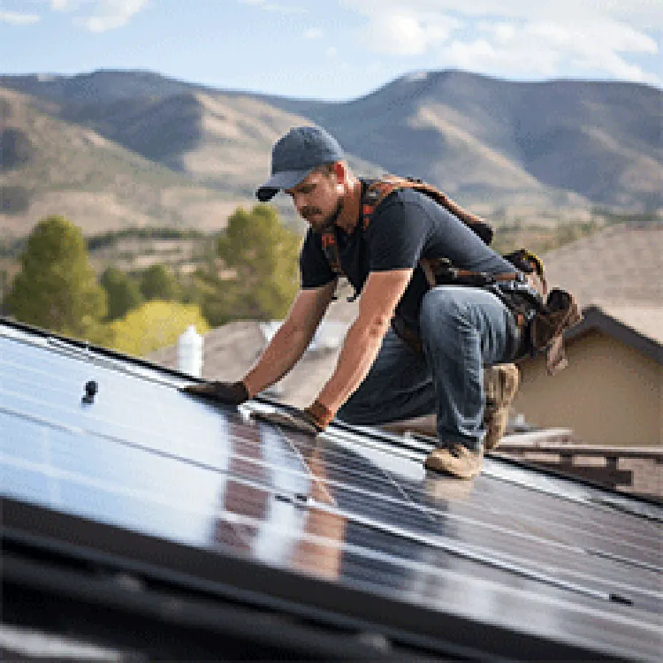 Worker fixing roof with beautiful mountain in the background.