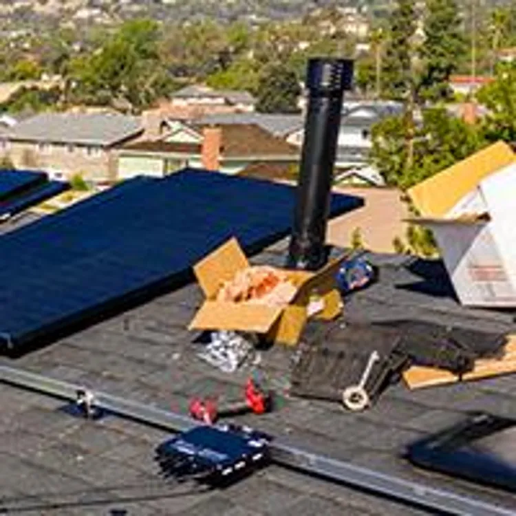 technicians installing solar panels on roof