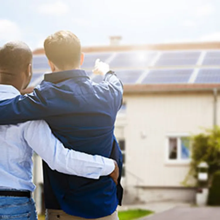 couple checking solar panels on a house