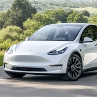 a white Tesla parked in a driveway