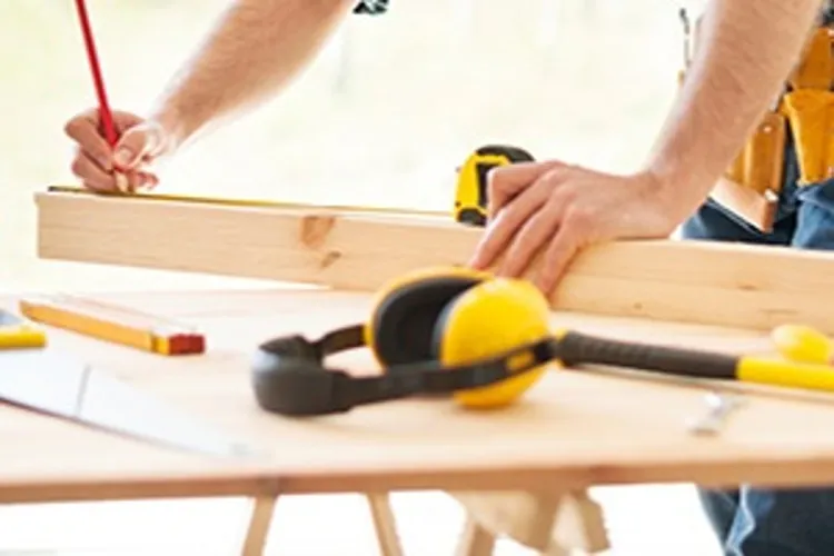 man measuring and cutting wood
