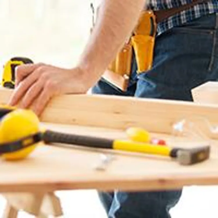 man measuring and cutting wood