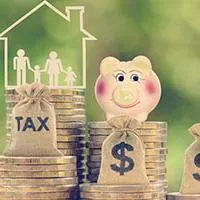 a house with a white silhouette of a family inside, dollar and tax bags and a piggybank on top of stacks of coins