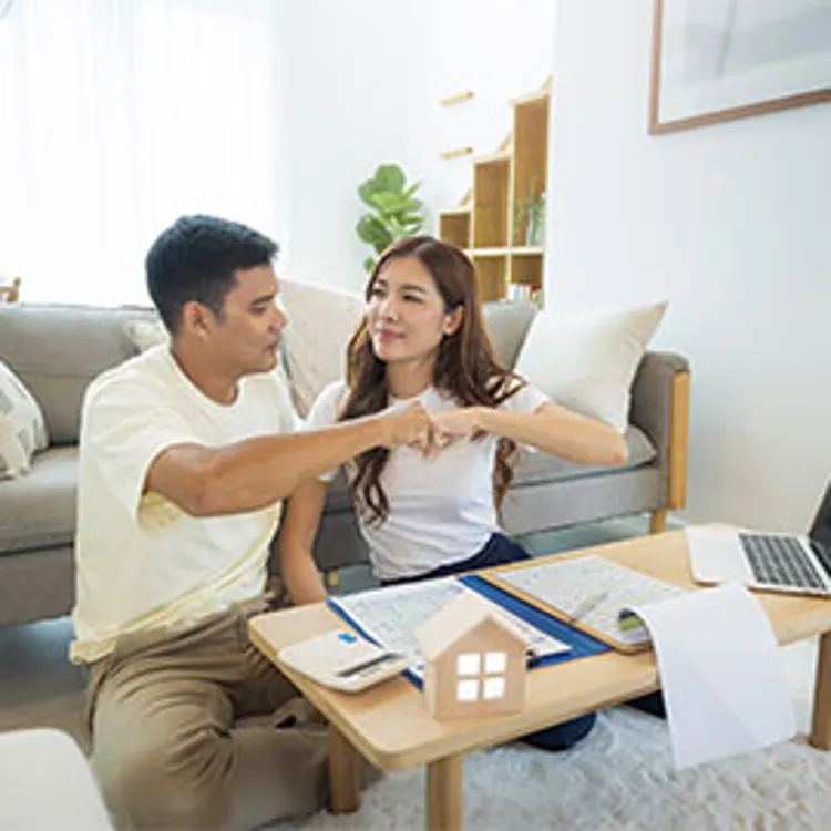 happy couple in apartment living room discussing plans