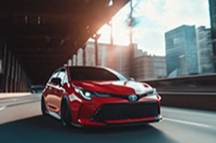 red toyota sedan on a city road