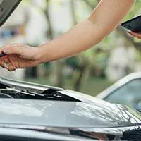 woman inspecting car engine
