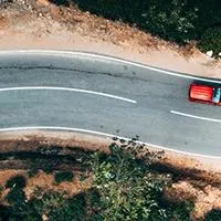red car driving on road