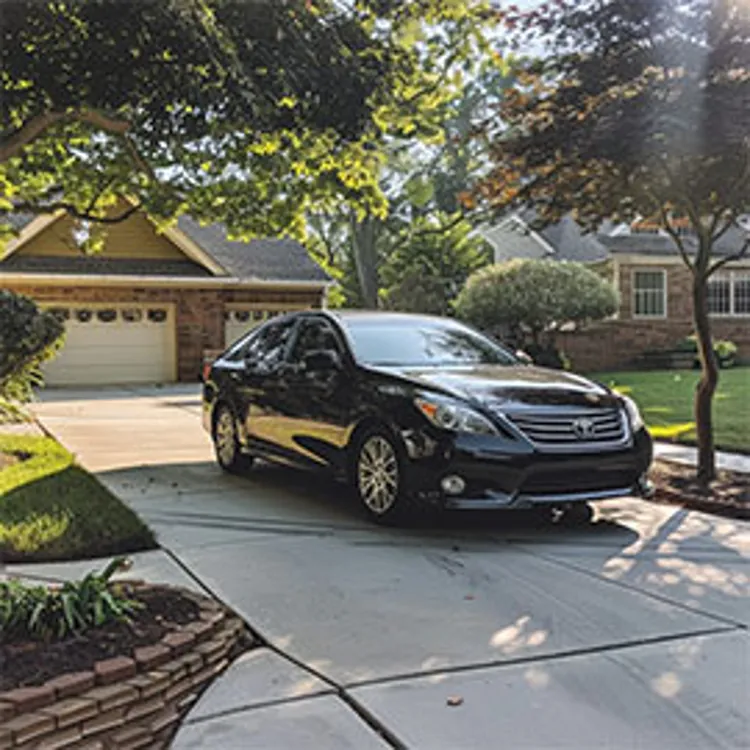 black car parked on the driveway of a home