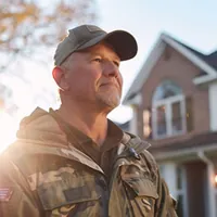 a war veteran in front of a house