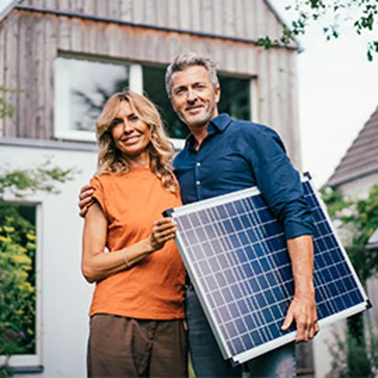 couple holding a solar panel
