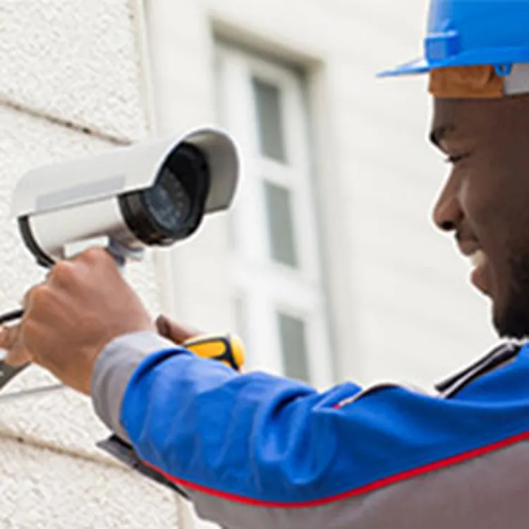 man installing home security camera
