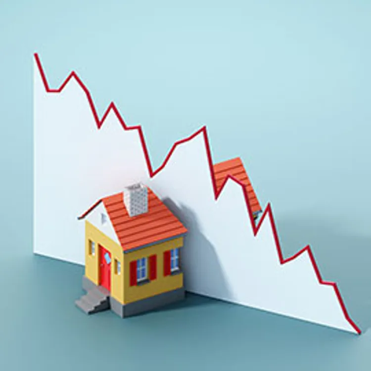 toy house cut into half by a falling line graph