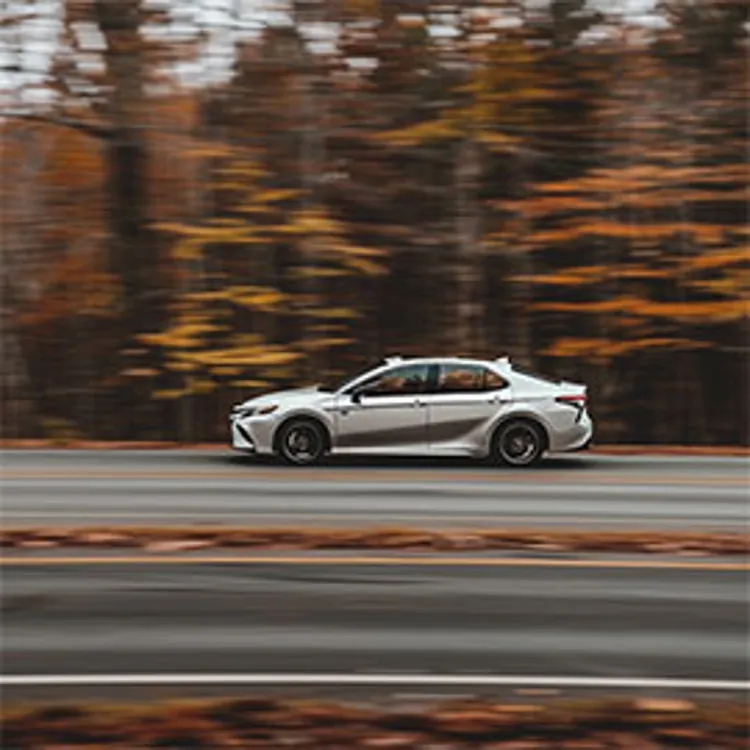 image showing a gray car speeding on the road