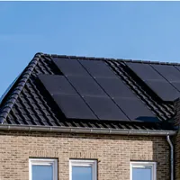 brick house with black solar panels on the roof