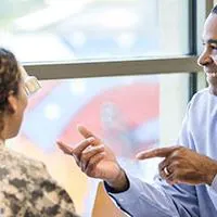 military couple talking to a credit union loan officer