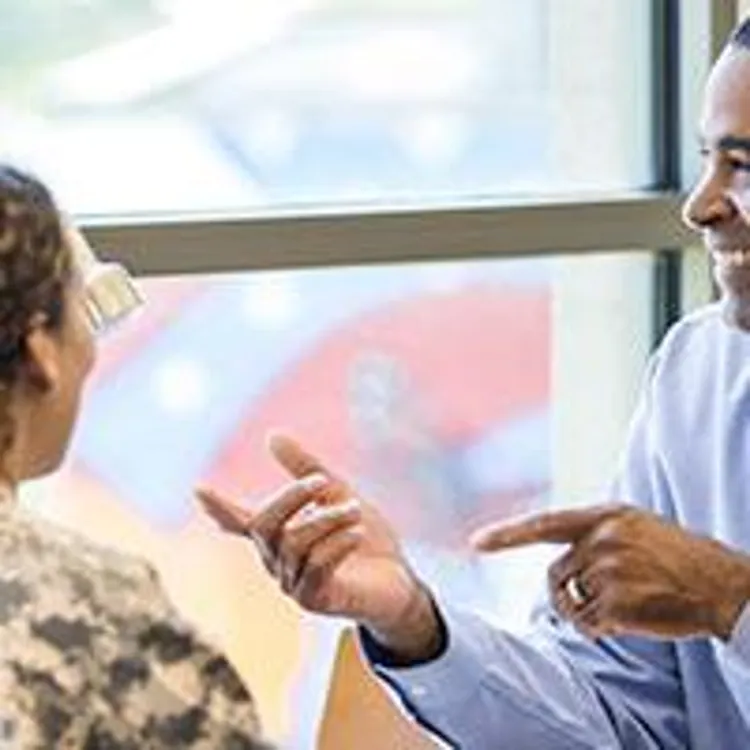 military couple talking to a credit union loan officer