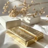 two gold bars set on a white cloth
