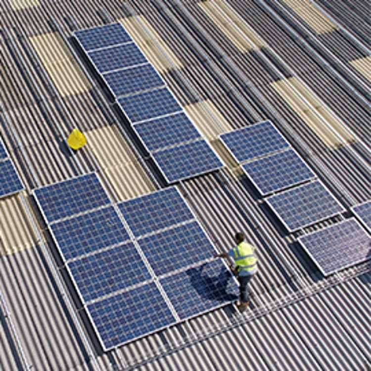 man installing solar panels on roof