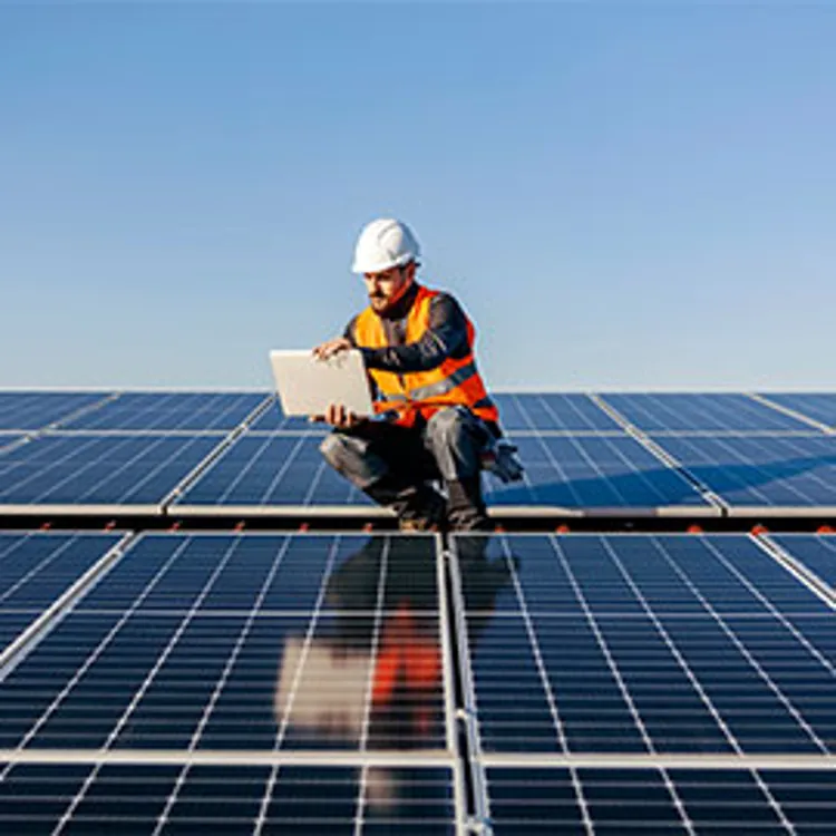 builder on top of a structure covered with solar panels