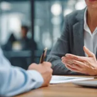 two people sitting across from each other in what appears to be an office setting