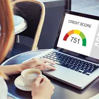 woman looking at credit score on laptop