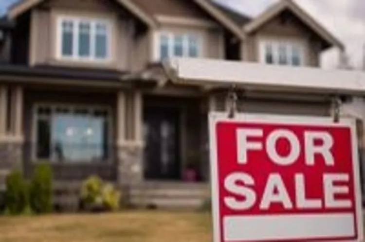 a two story house with a house for sale sign in the front
