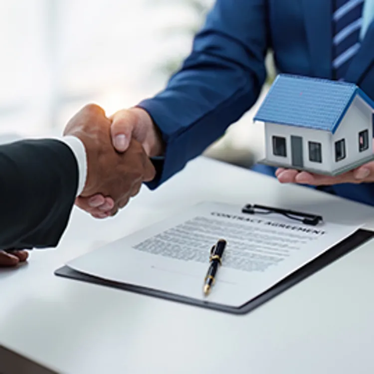 agent and client shake hands after signing papers