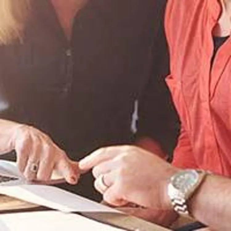 couple looking at paperwork and computer with woman