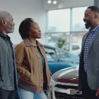 a couple speaking to a salesman at the dealership