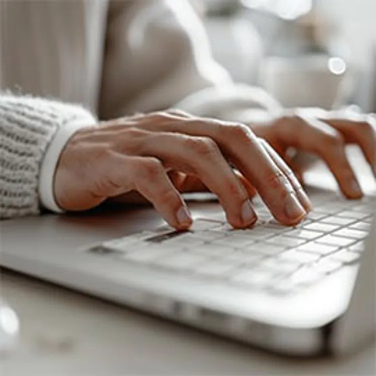 hand typing on a laptop keyboard