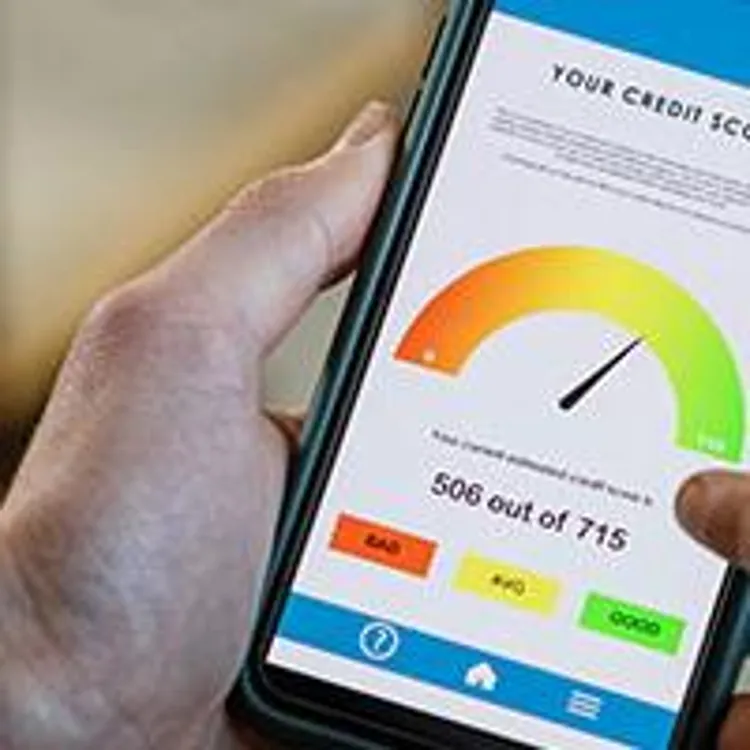 hands holding a mobile phone showing credit score