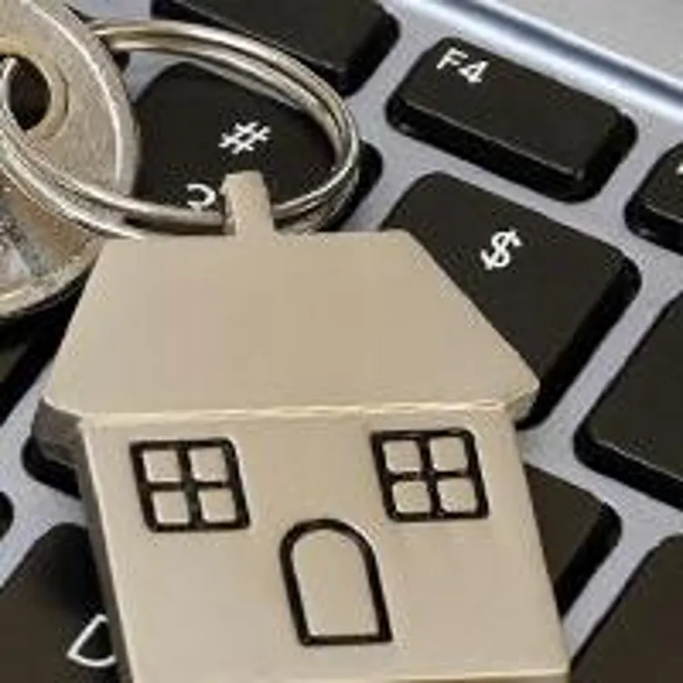 key with metallic house keychain on laptop keyboard