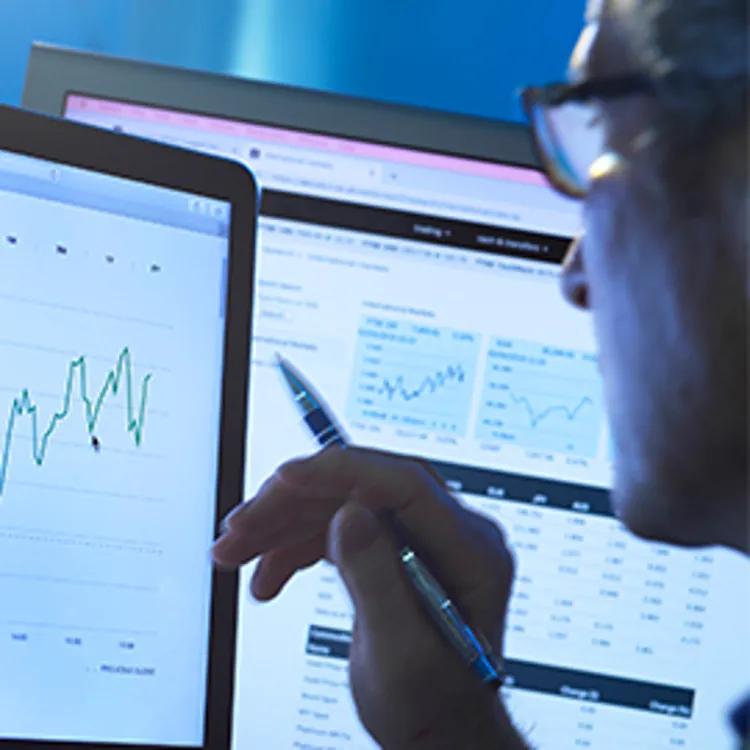 analyst looking at stock data on computer