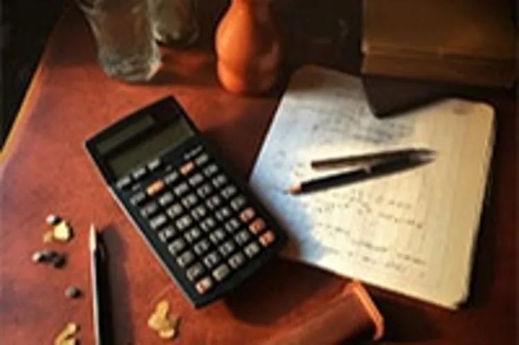 paper with calculations beside a calculator and pencils on a table