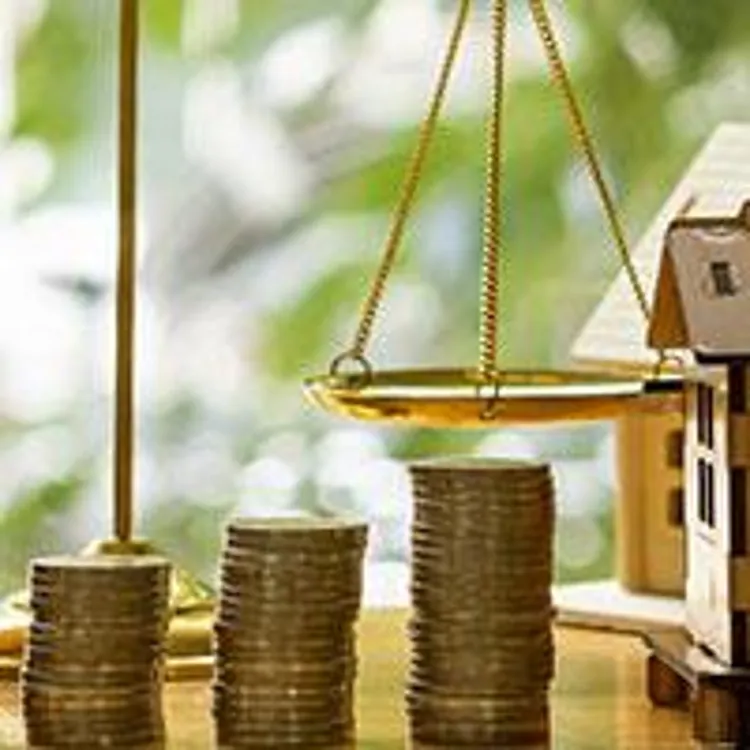 small house with stacks of coins, gavel, and legal scales