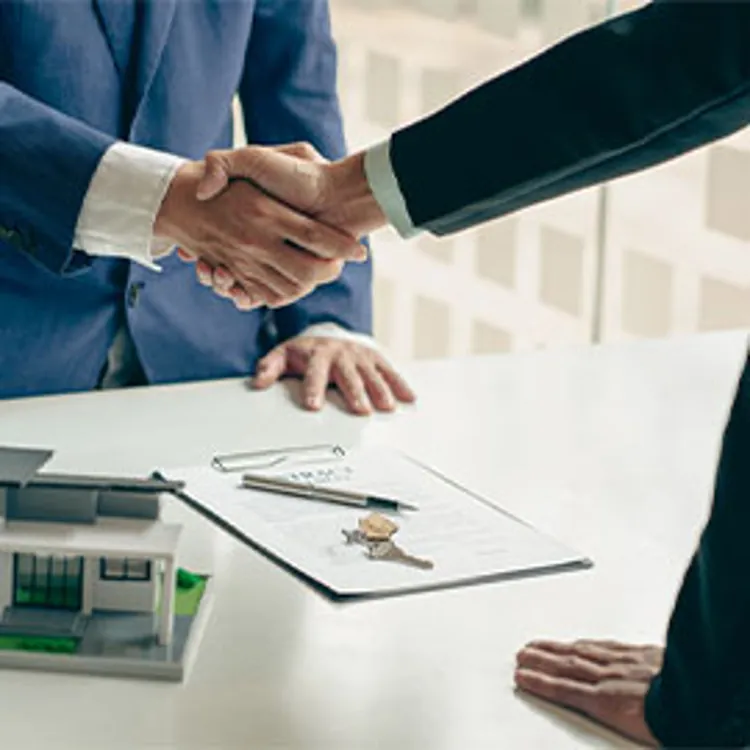two men shaking hands upon closing the deal on a house purchase