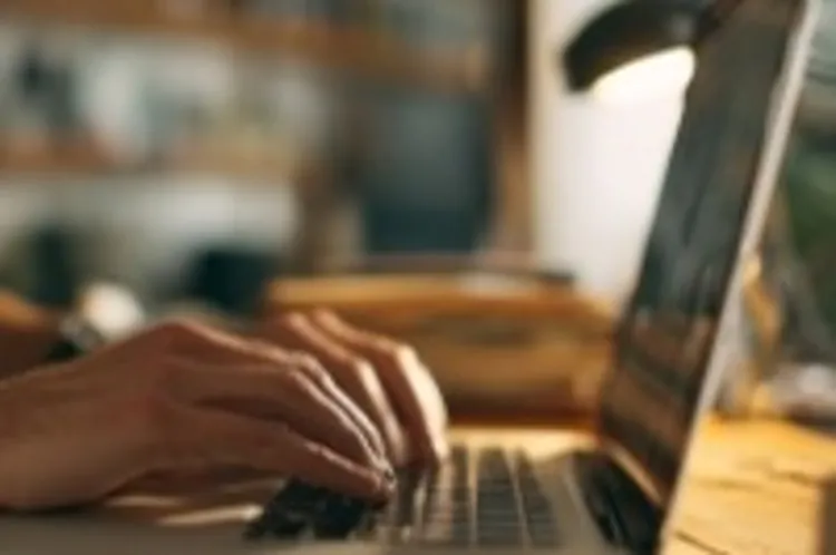 a laptop with someone typing on it