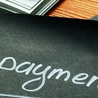 black piece of paper with the word prepayment written in white ink on a table
