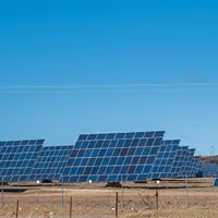 solar panels with tracker on a field under blue sky