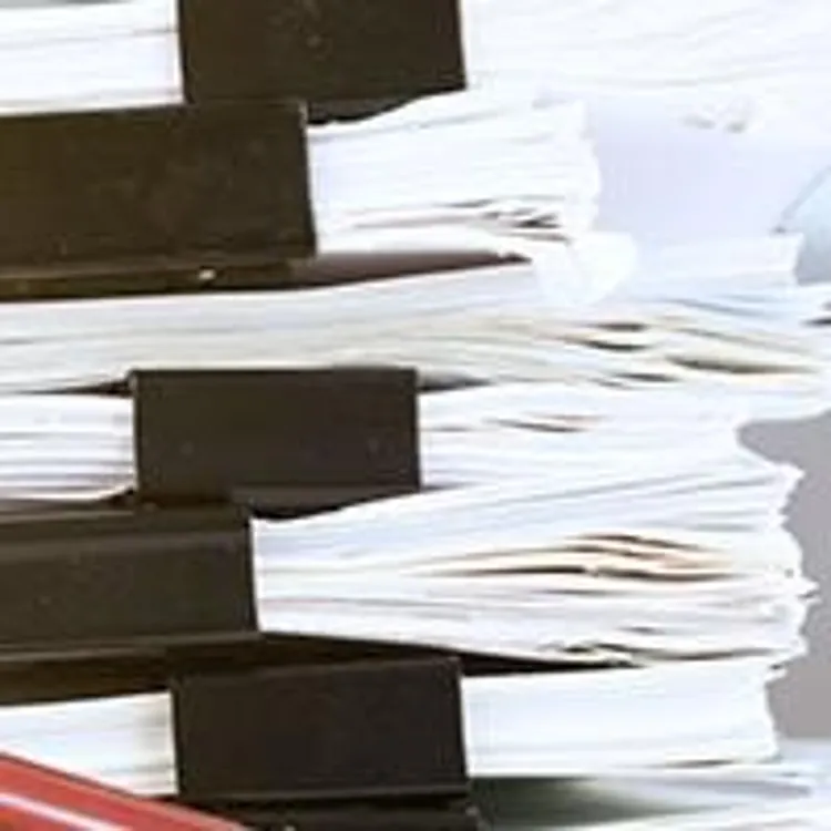 magnifying glass looking at a stack of papers