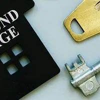 small house with wraparound mortgage engraved and keys in the background