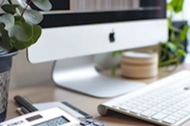calculator in the foreground with an iMac in the background