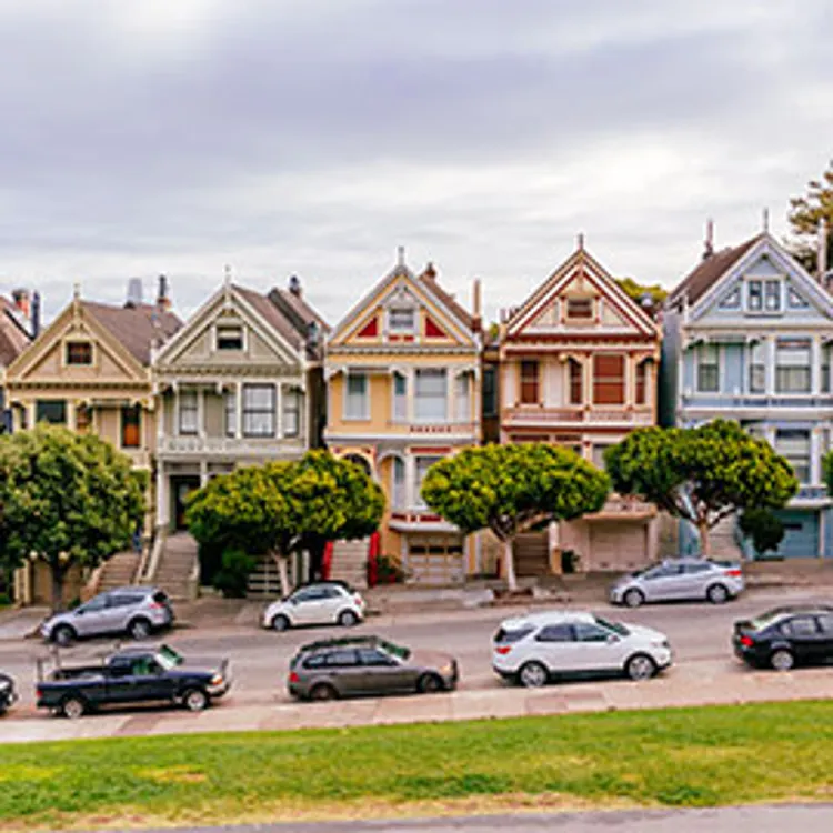 row of houses with cars parked on the street