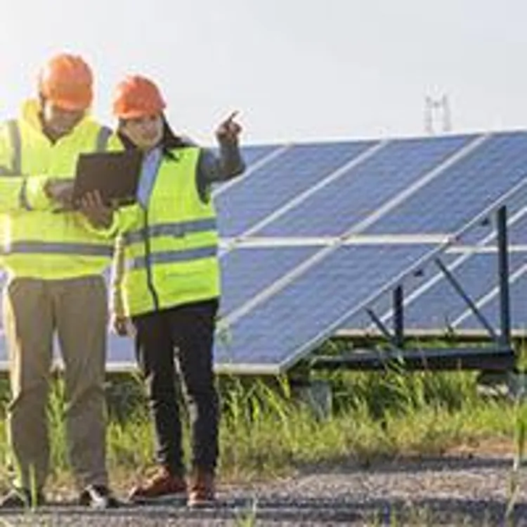 three workers on a solar power farm