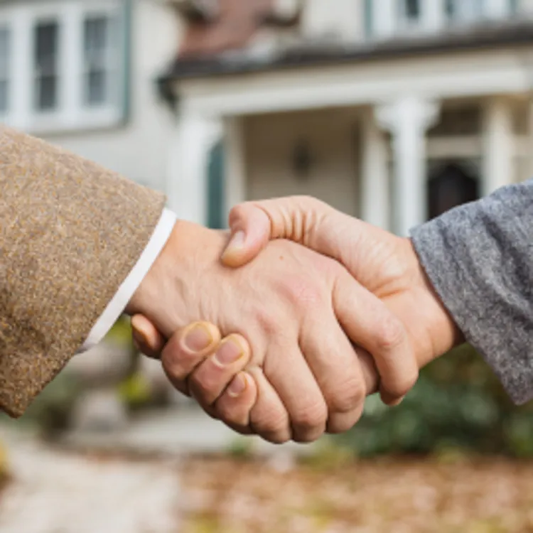 handshake in front of a new house