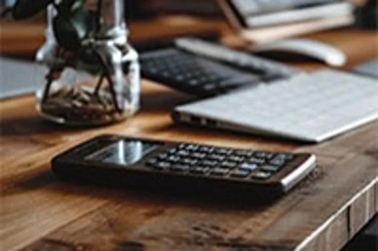 calculator beside a closed laptop on a table