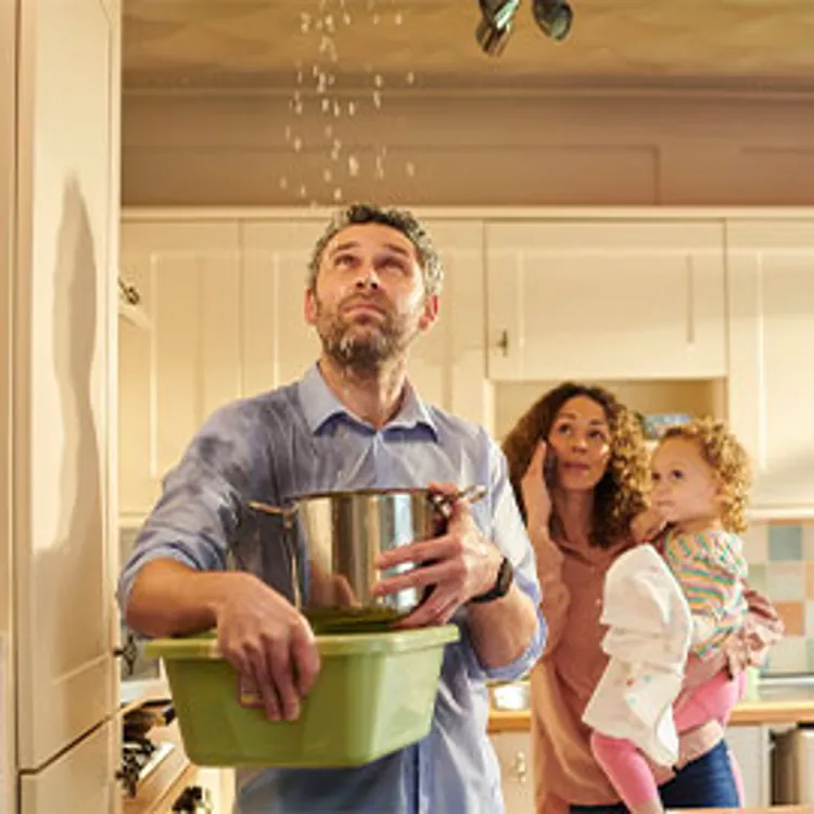 family with toddler looking at water leaking from ceiling