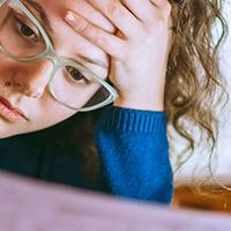 woman looking at paperwork with a worried look on her face